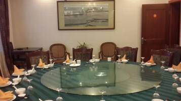 A conference room with a round glass table, chairs, and a framed picture on the wall.