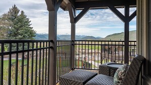 A covered outdoor seating area with a view of a mountainous landscape.