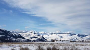 A panoramic view of a snow-covered mountainous landscape with a clear sky.