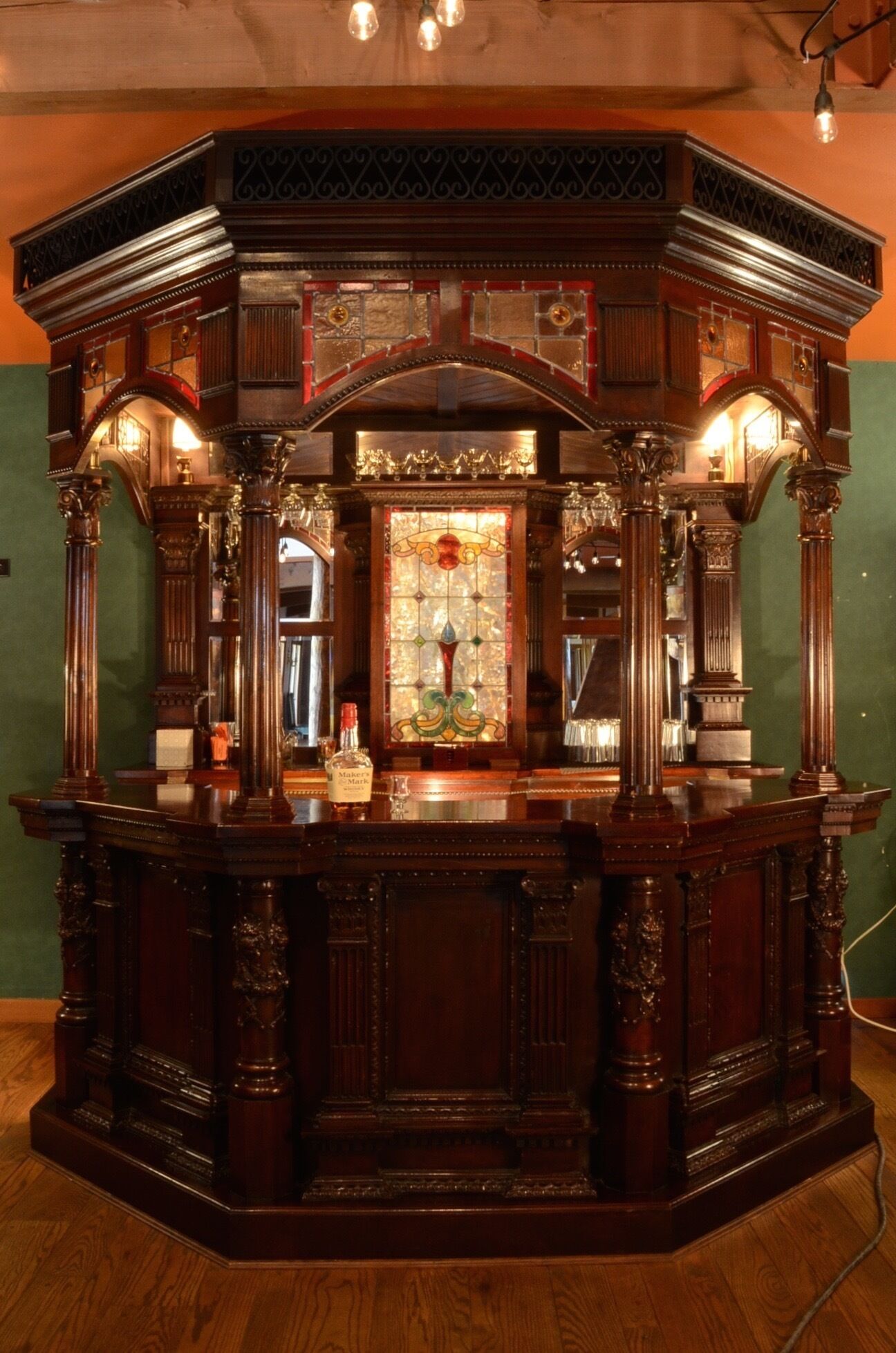 Un comptoir en bois orné de sculptures complexes et agrémenté d’une fenêtre en vitrail.