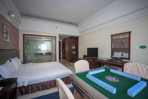 Une chambre d’hôtel équipée d’un lit, d’un bureau avec un ordinateur, d’une télévision et d’une table de billard.