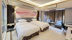 A hotel room with two beds, a desk, a chair, and a large window. - Sanshui Sunshine Holiday Hotel (Foshan)