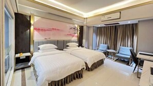 A hotel room with two beds, a small table, a chair, and a large window with curtains. - Sanshui Sunshine Holiday Hotel (Foshan)