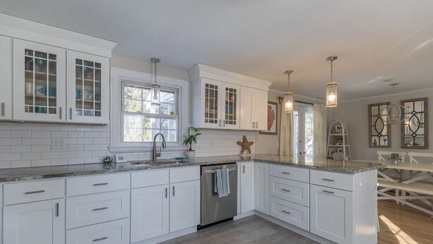 A modern kitchen with white cabinetry, a granite countertop, and pendant lighting. - Adorable, Bright and By the Bay! (Falmouth)