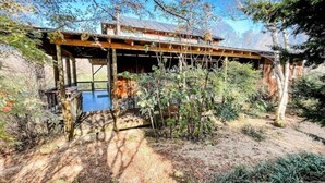 Eine rustikale Holzhütte mit einer Holzdiele und einem kleinen Teich.