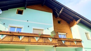 A two-story building with a balcony, wooden railings, and flower boxes. - Aliegusta (Gitschtal)