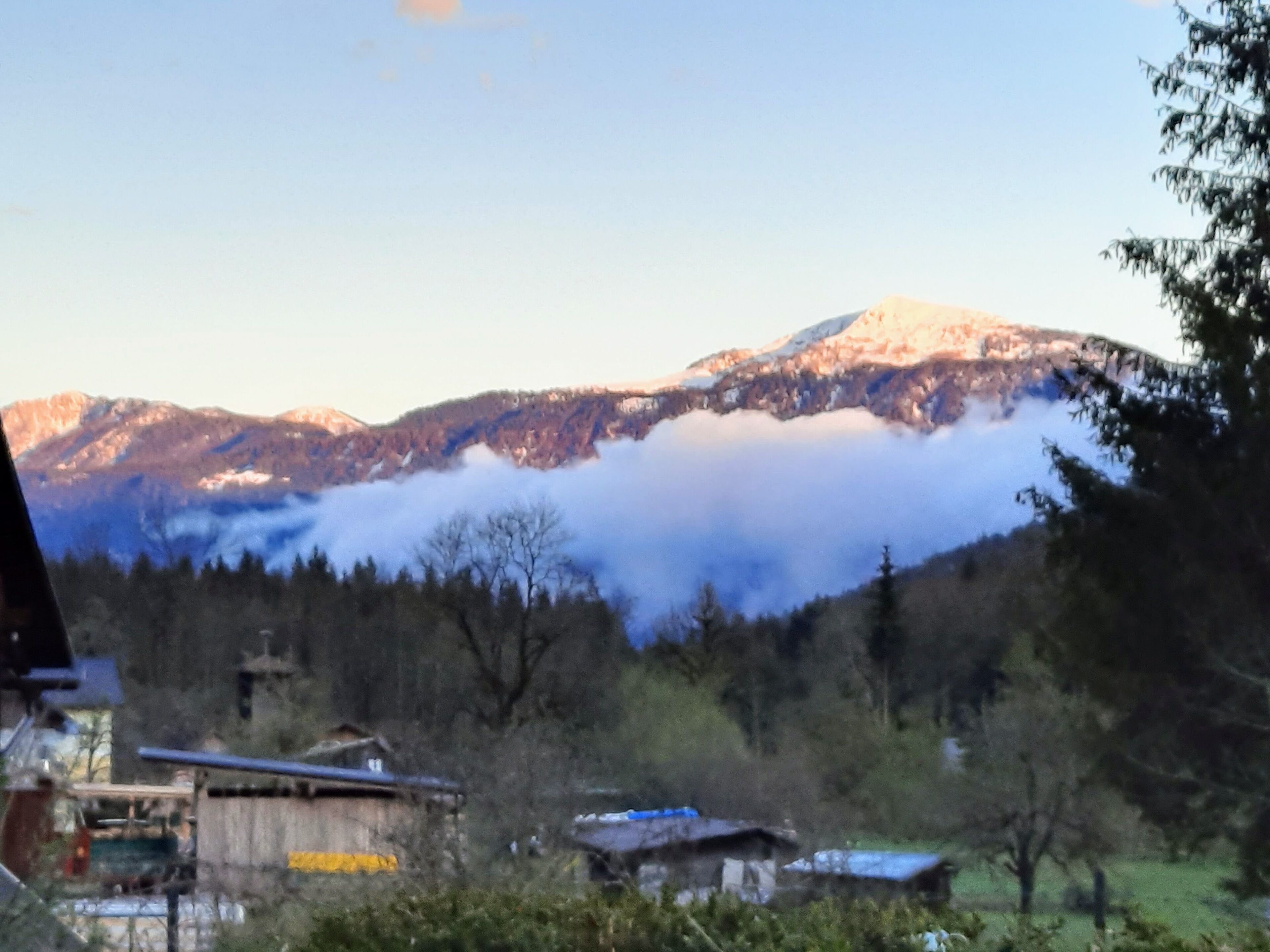 Eine Berglandschaft mit einem Dorf im Vordergrund.