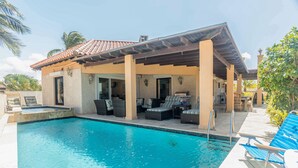 Ein Poolbereich mit Liegestühlen und einer überdachten Terrasse.