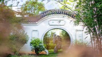 A traditional archway with a tiled roof, surrounded by greenery.