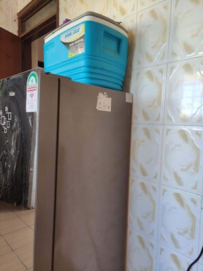 Refrigerator with a water dispenser is conveniently located in this room.