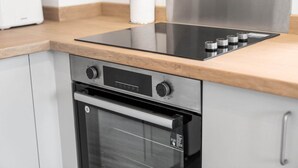 Una cocina moderna con horno empotrado, placa de cocina y encimera.