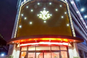 Un edificio con un emblemático letrero iluminado en la fachada, amplias ventanas y una entrada curva.
