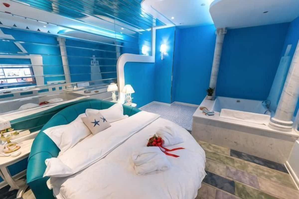Une chambre d’hôtel moderne dotée d’un grand lit, d’une baignoire et d’un coin repas.