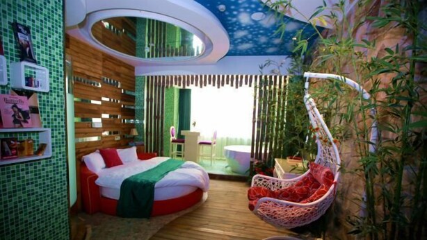 Una habitación con cama, una silla colgante, una mesita y vistas al exterior.
