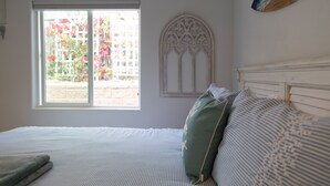 Een slaapkamer met een bed, een raam en een decoratief wandobject.