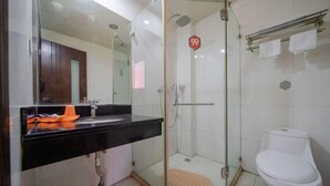 A modern bathroom with a glass shower enclosure, a white toilet, and a black countertop with a mirror. - 99 Inn Chain (Changshu Fangtayan Baibaiban) (Changshu)