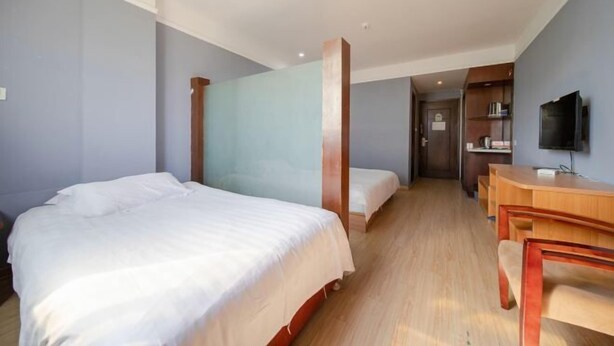 A hotel room with a large bed, a smaller bed, a desk, and a television. - 99 Inn Chain (Changshu Fangtayan Baibaiban) (Changshu)