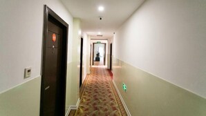 A hotel hallway with carpeted floors, doors, and a light fixture on the ceiling. - 99 Inn Chain (Changshu Fangtayan Baibaiban) (Changshu)