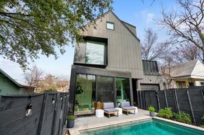 A modern two-story house with a swimming pool, a fenced backyard, and a clear sky. - Heated Pool Oasis, Walkable Prime Location, Skyline Views, Chefs Kitchen (Austin)