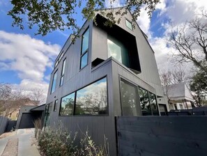 A modern two-story building with large windows and a flat roof. - Heated Pool Oasis, Walkable Prime Location, Skyline Views, Chefs Kitchen (Austin)