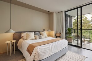 Relax in this serene bedroom with a large bed, bedside table, and comfortable chair.