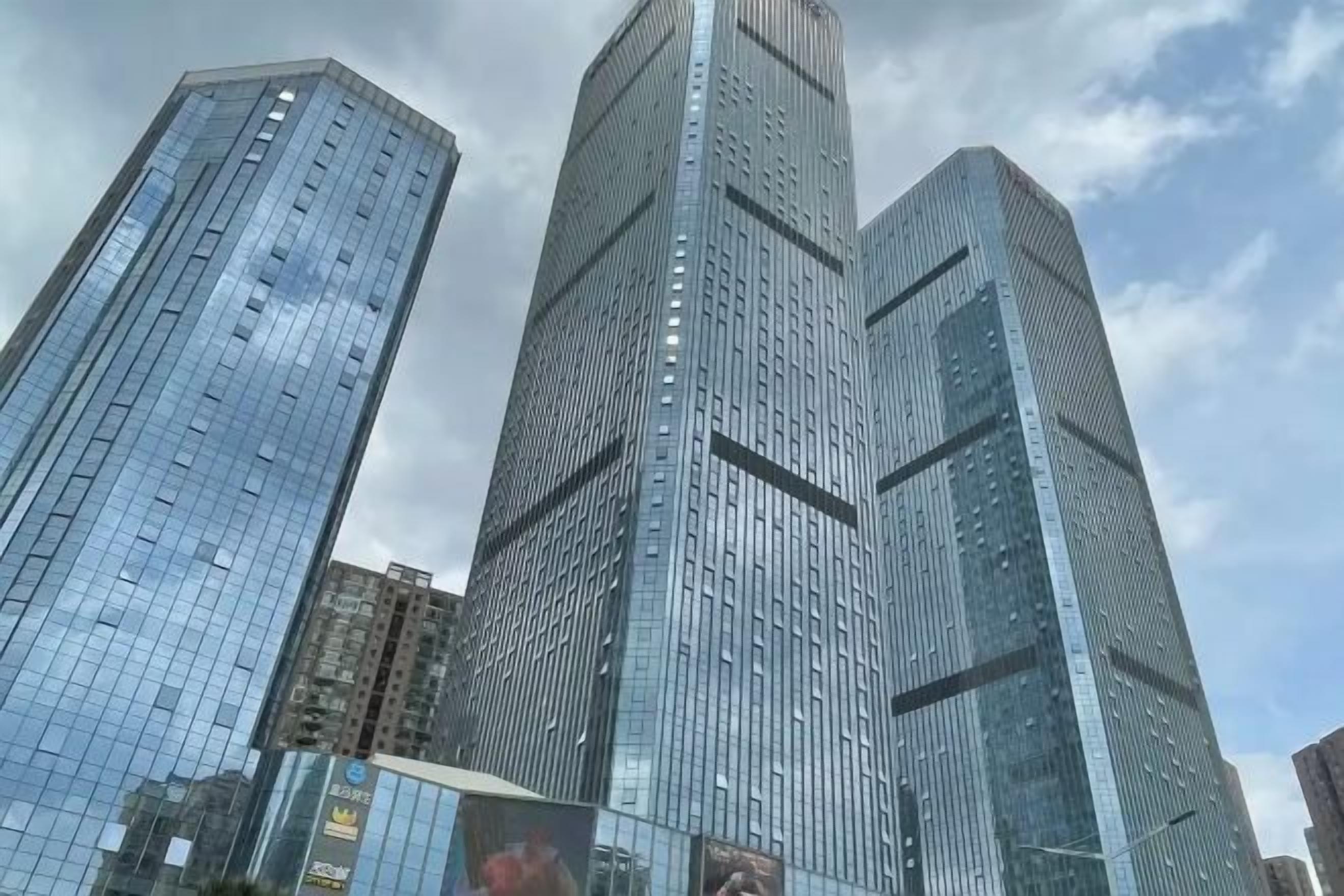A cluster of high-rise buildings with reflective glass facades, likely part of a business district.