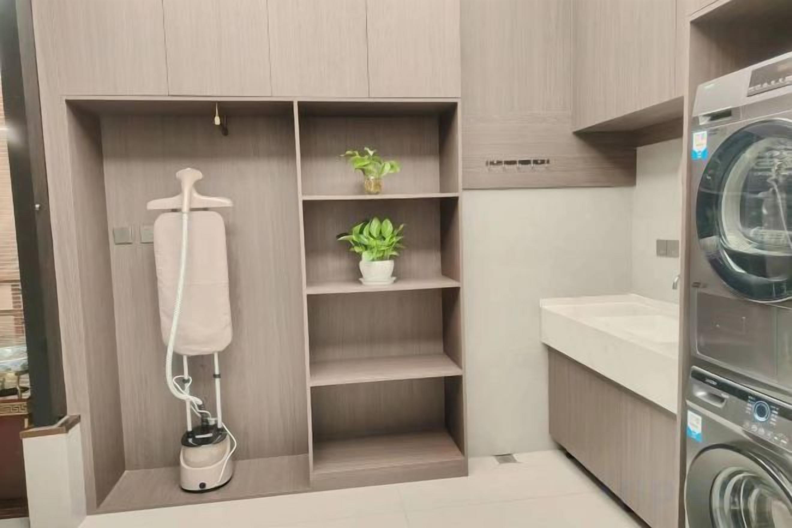 A laundry area with a washing machine, a drying machine, and a drying rack.