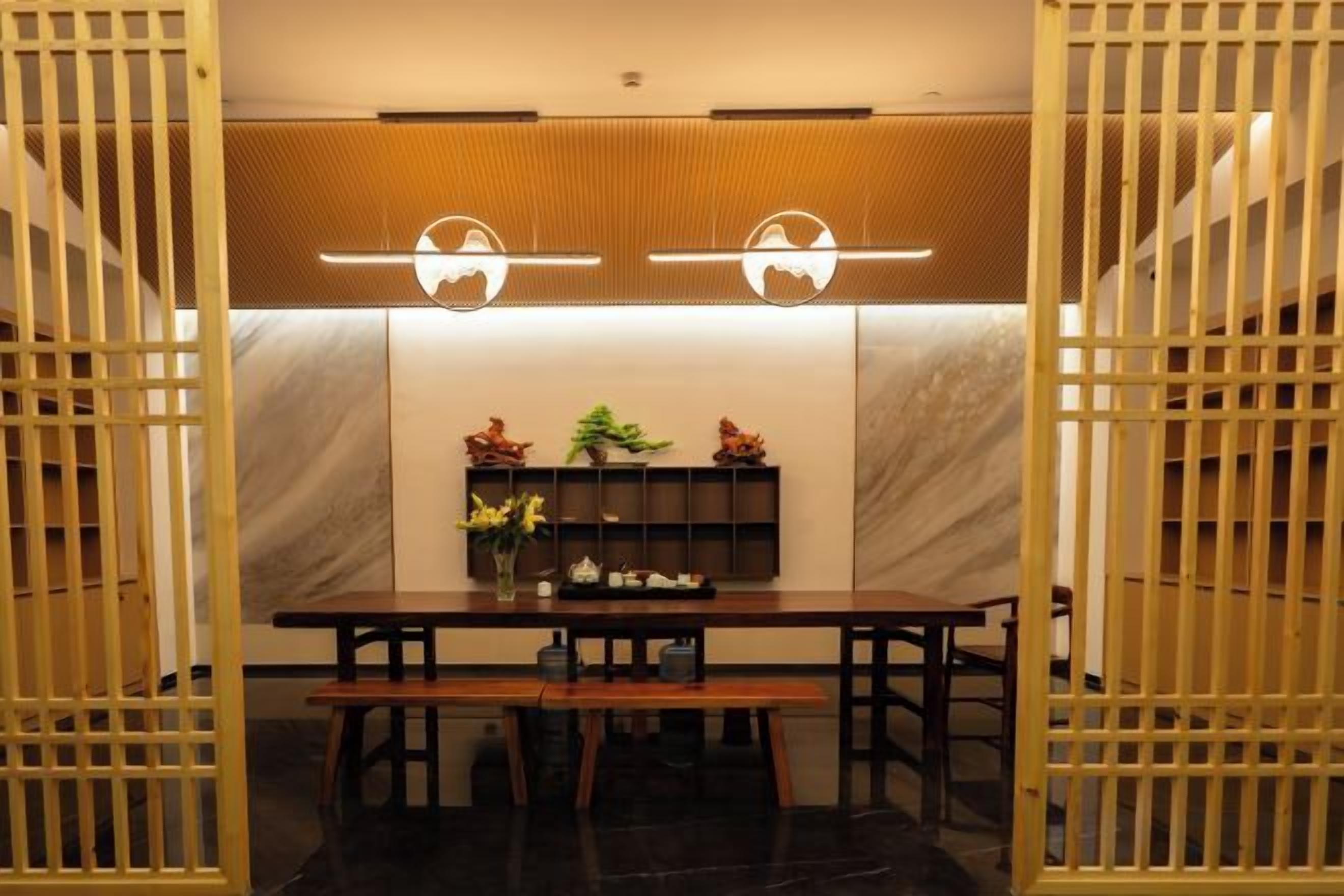 Un comedor con una mesa, bancos y una pared decorativa con estantes.