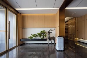 A modern interior with a polished floor, a bench with a decorative deer sculpture, and a wall-mounted plant. - Kunming Panlong Days Inn Selected Wyndham Hotel (Agricultural University Branch) (Kunming)