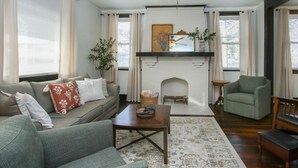 Un salon avec une cheminée, un canapé, une table basse et un fauteuil.