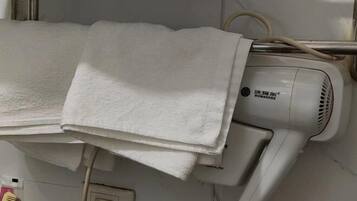 A hair dryer with a label, a towel, and a power outlet.
