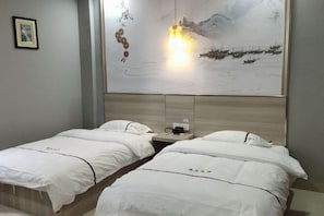 A hotel room with two beds, a painting, and a nightstand.