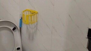 A bathroom with a toilet, a yellow basket, and a blue toothbrush. - Tengyun Hotel (Huaiji)