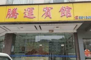 A storefront with a yellow sign and large windows. - Tengyun Hotel (Huaiji)