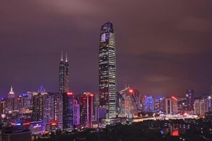 A city skyline at night with illuminated buildings.