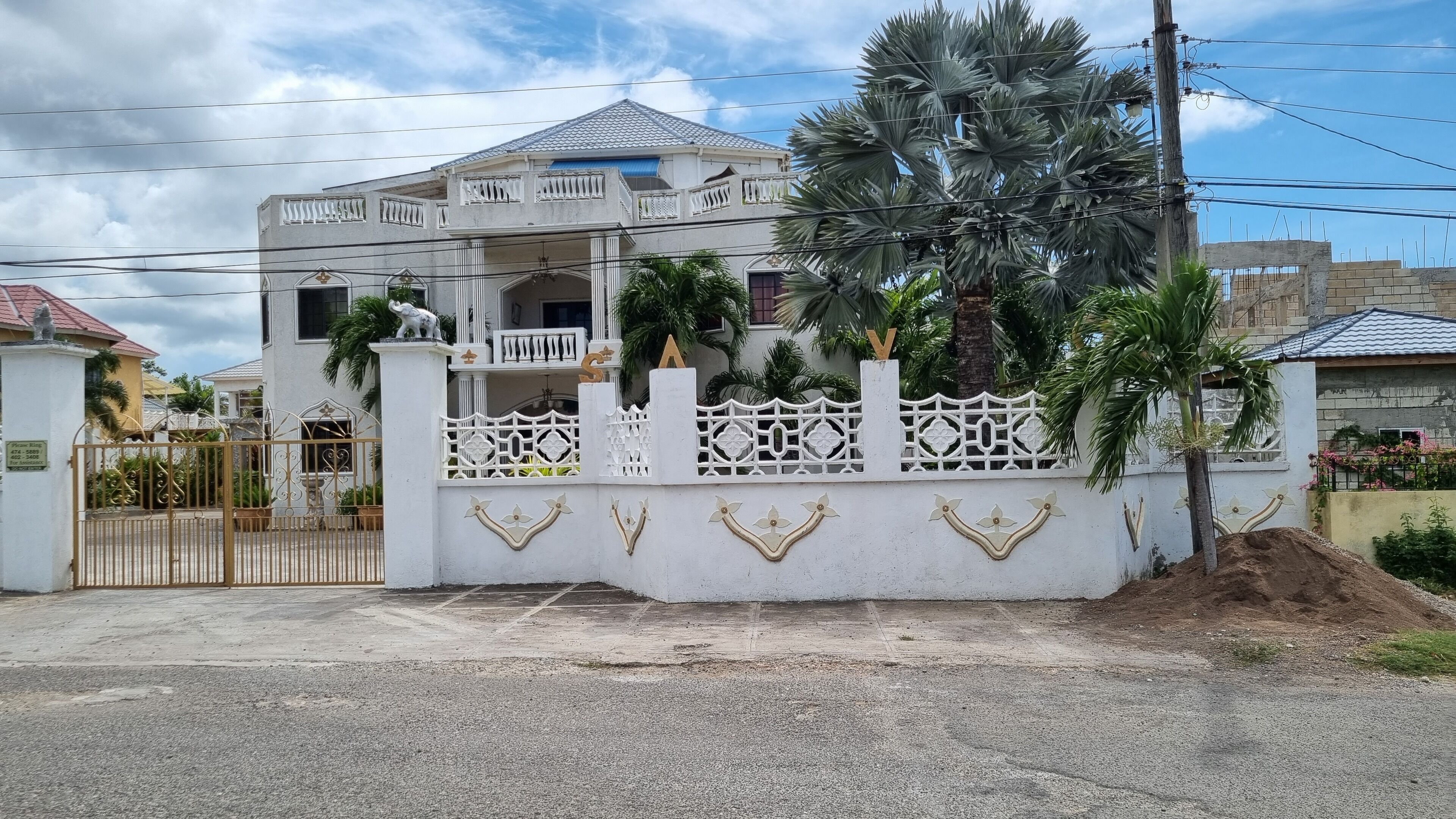 A two-story house with a white exterior, a balcony, and a decorative fence.