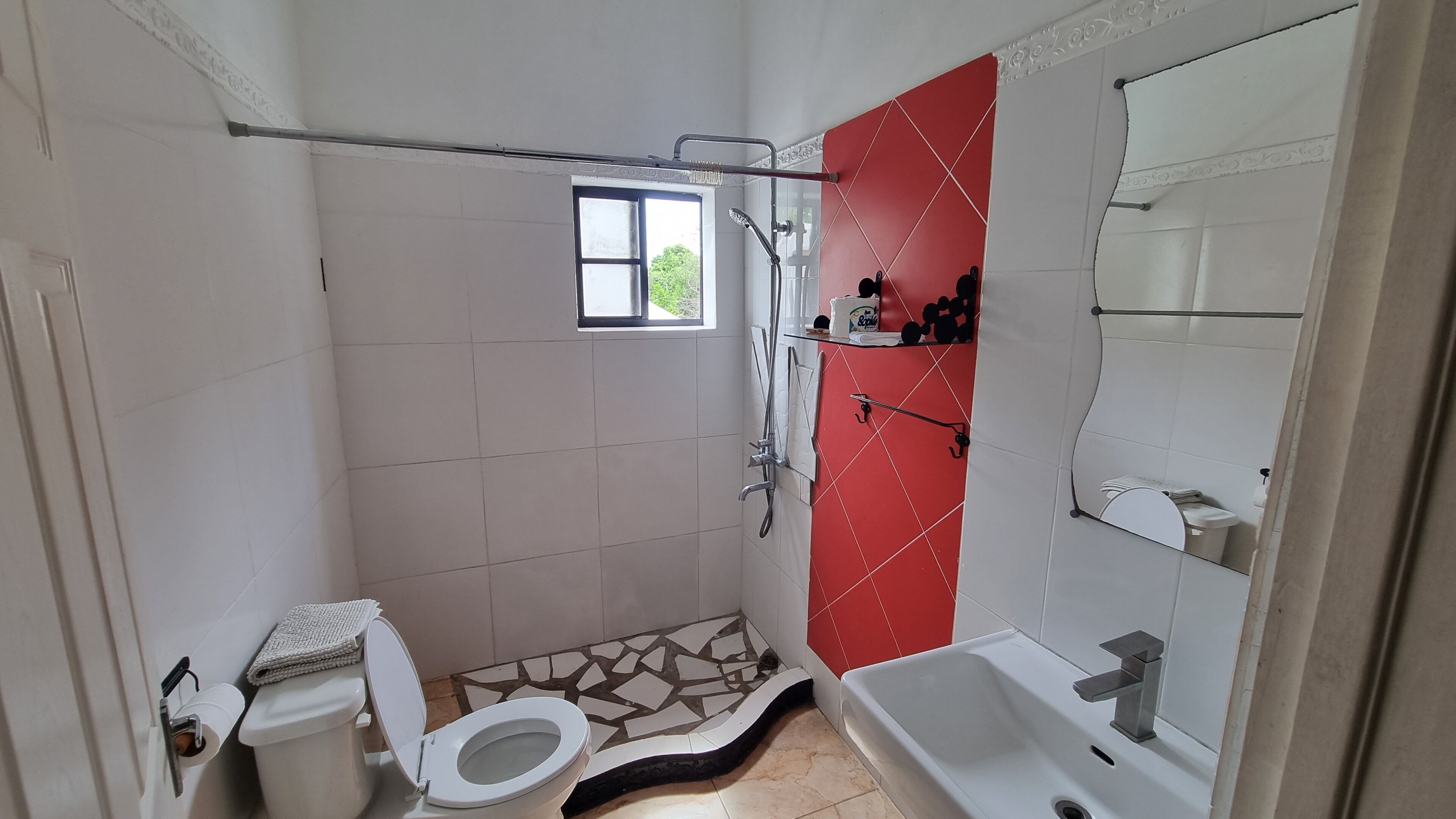 A small bathroom with a toilet, a shower, and a sink.