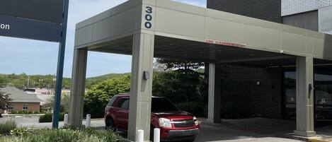 A parking garage entrance with a red SUV parked inside, marked with the number 300.