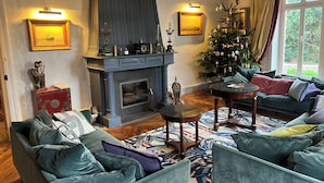 Een gezellige woonkamer met een open haard, een kerstboom en een bank.