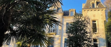 Un edificio grande e histórico con una torre destacada y numerosas ventanas.