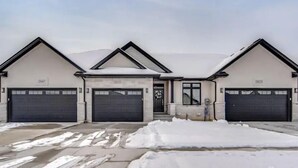 A two-story building with three garage doors, numbered 2457, 2458, and 2459. - Luxurious 3BR, King Bed, Ensuite. Perfect Stay! (Windsor)