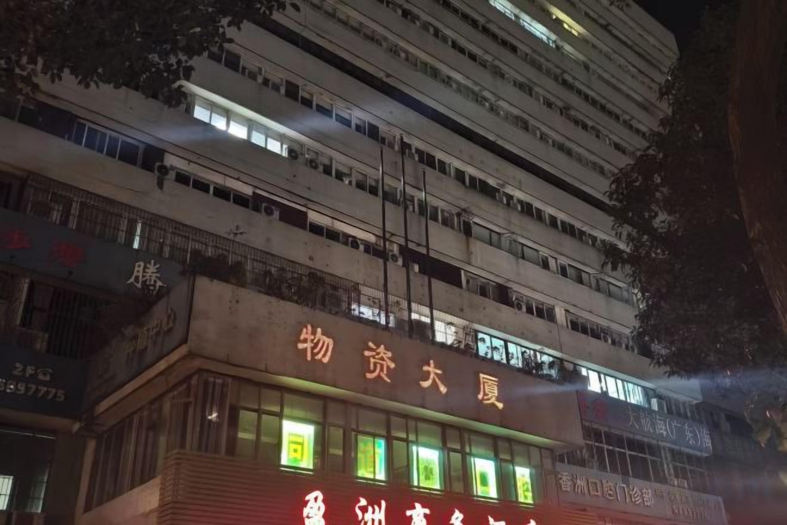 A multi-story building with illuminated signage, likely a hotel or commercial property.