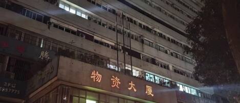 Un immeuble à plusieurs étages, doté d’une enseigne lumineuse, qui est probablement un hôtel ou un immeuble commercial.
