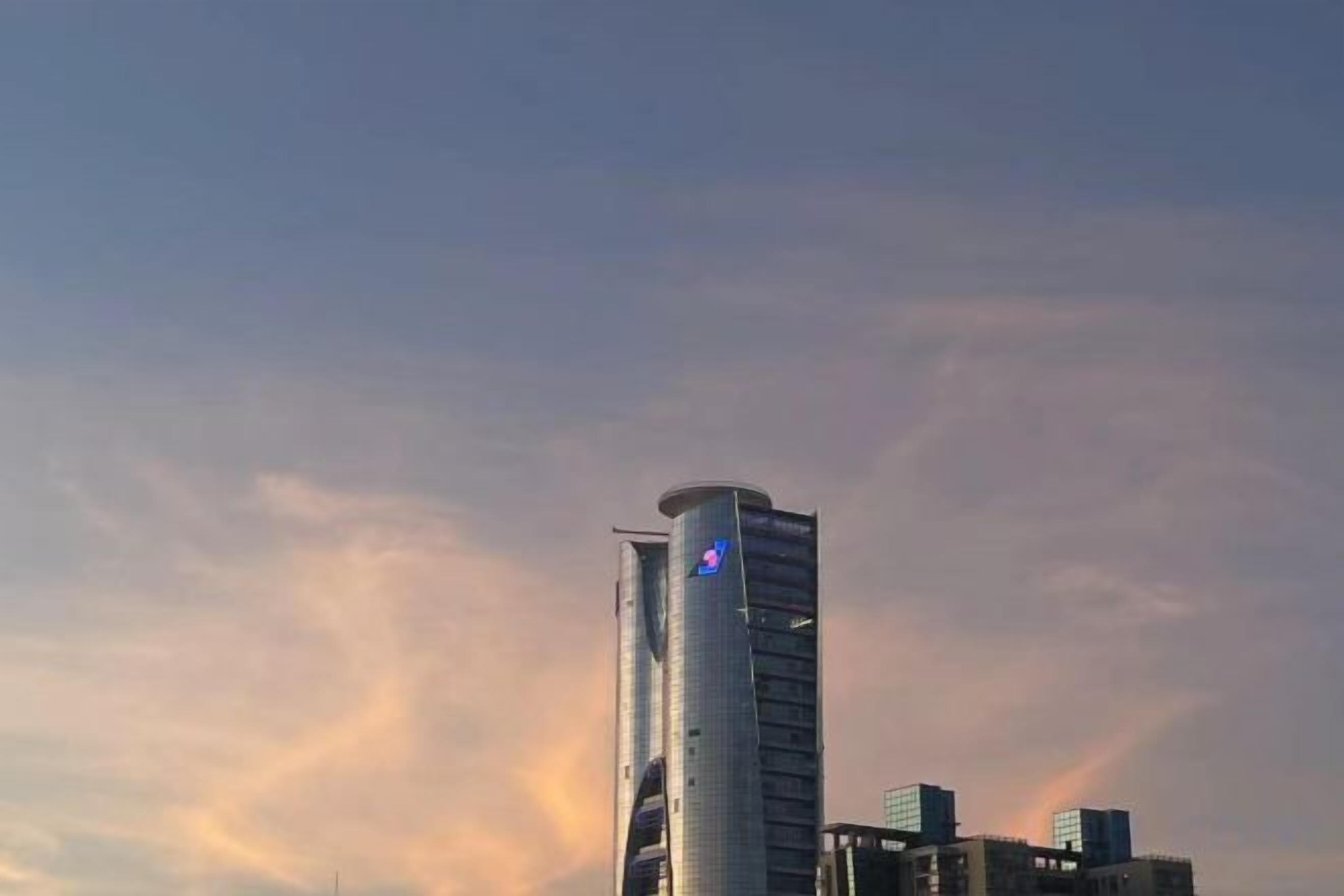 A tall building with a distinctive curved top and a visible logo.