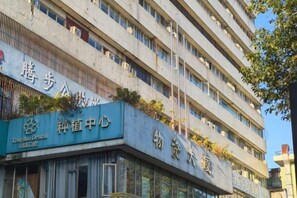 A multi-story building with signage indicating a pharmacy and a center for genetic testing. - Yingzhou Business Hotel (Zhuhai)