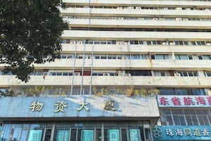 A multi-story building with signage indicating it is a property management office. - Yingzhou Business Hotel (Zhuhai)