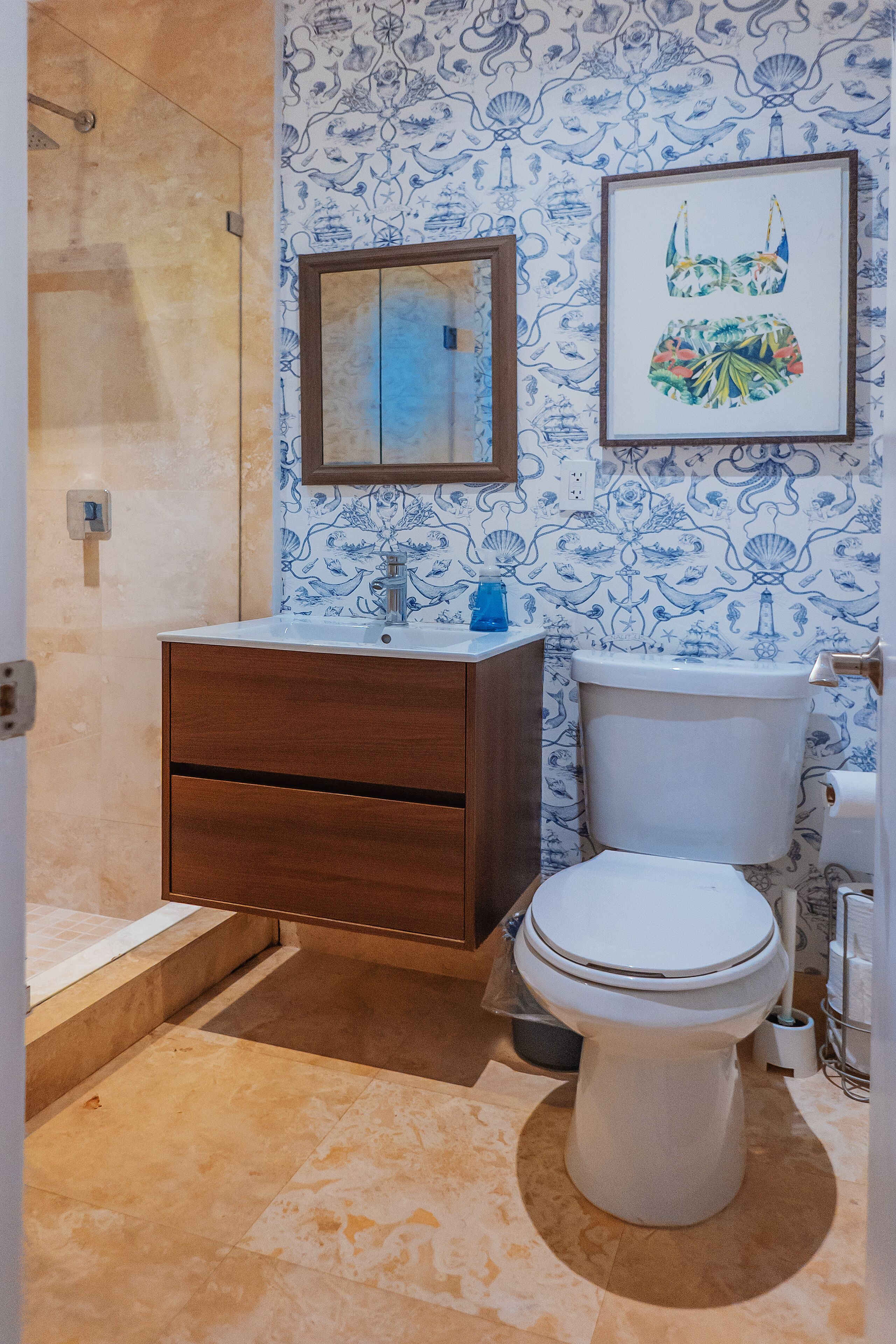 A bathroom with a shower, a sink, a toilet, and a mirror.