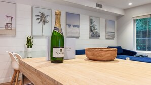 A modern kitchen with a wooden countertop, a green bottle of champagne, and a woven basket. - Casa Coco: Private Designer Home Pool / Close to Brickell & Coconut Grove (Miami)
