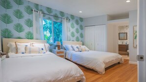 A bedroom with two beds, a window with a view of greenery, and a wooden floor. - Casa Coco: Private Designer Home Pool / Close to Brickell & Coconut Grove (Miami)