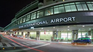 Terminal del Aeropuerto Internacional de Miami, con vista despejada a la entrada y un coche azul estacionado afuera.